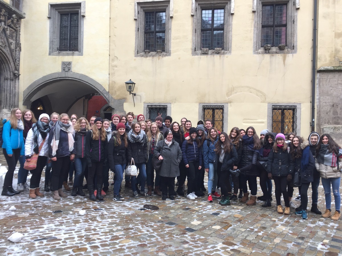 Gruppe von Menschen vor historischem Gebäude im Winter