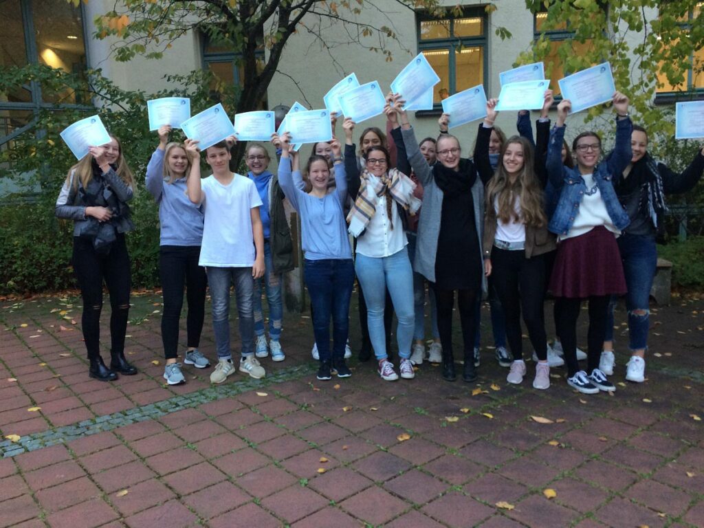 Gruppe von Schülern mit Zertifikaten im Freien