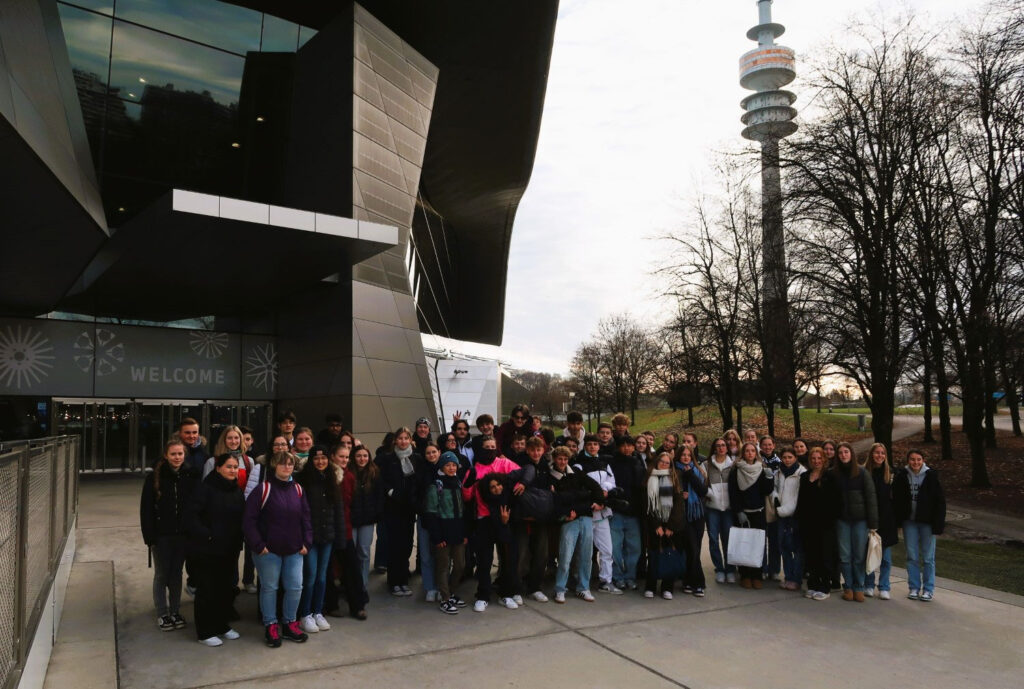 Gruppe tourt vor moderner Architektur und Fernsehturm