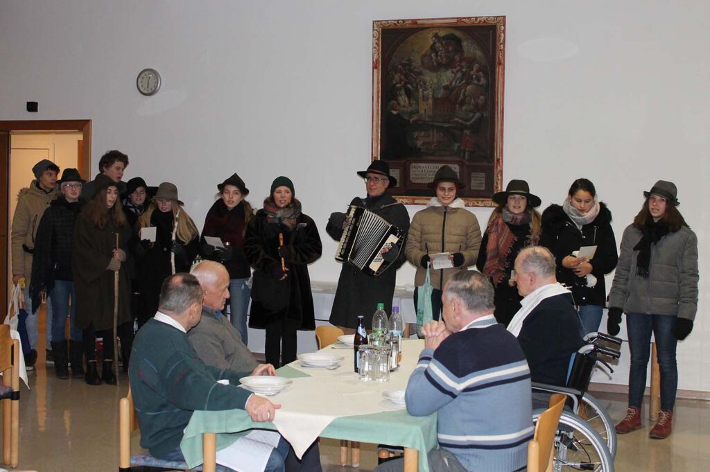 Gruppe von Menschen singt in einem Seniorenheim