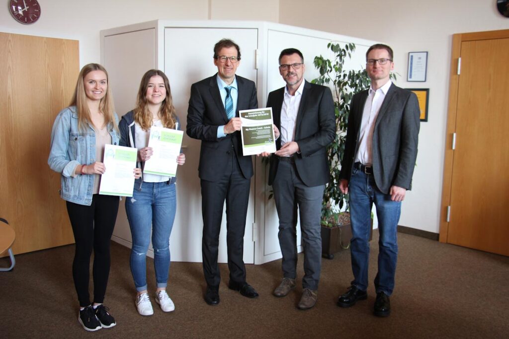 Gruppe von Menschen hält Zertifikate in Büro