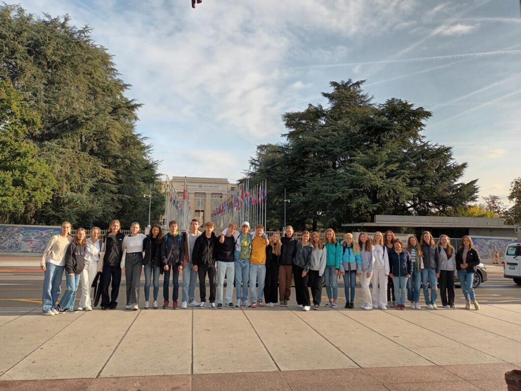 Gruppe posiert vor internationalen Flaggen im Freien