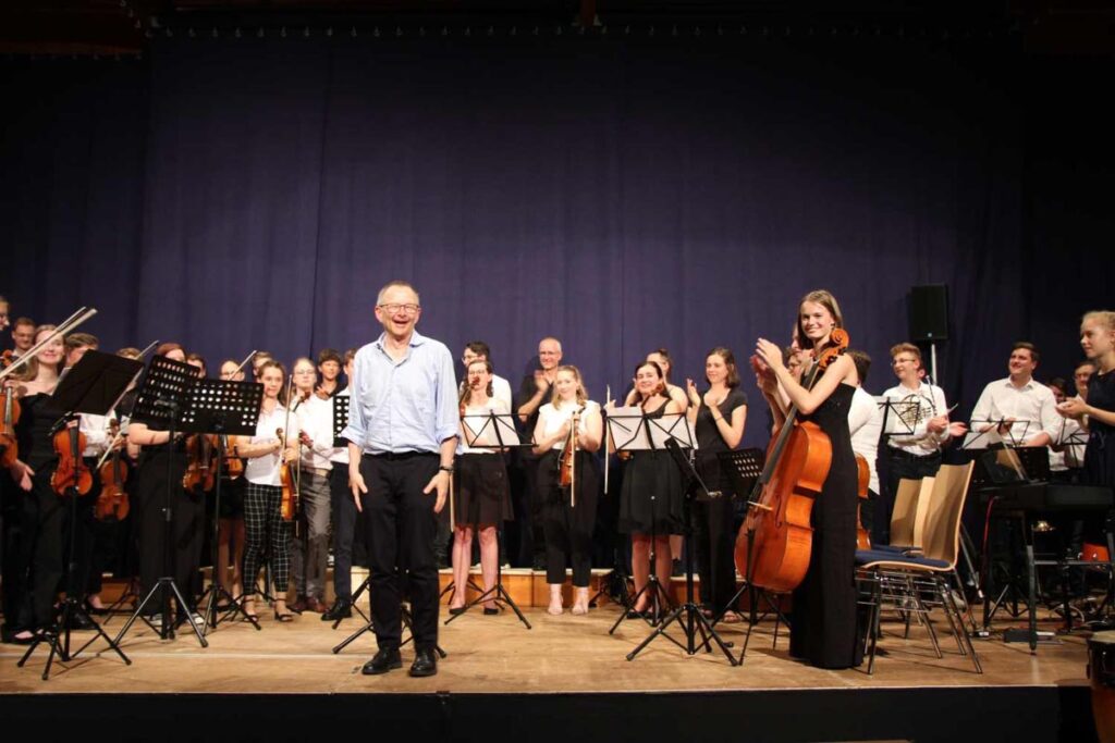 Orchester auf Bühne nach erfolgreichem Konzertauftritt applaudierend