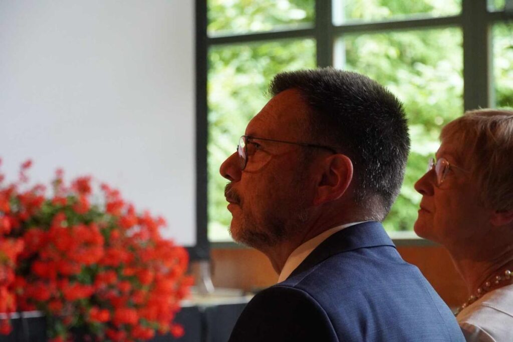 Zwei Personen in einem Raum mit Blumen.