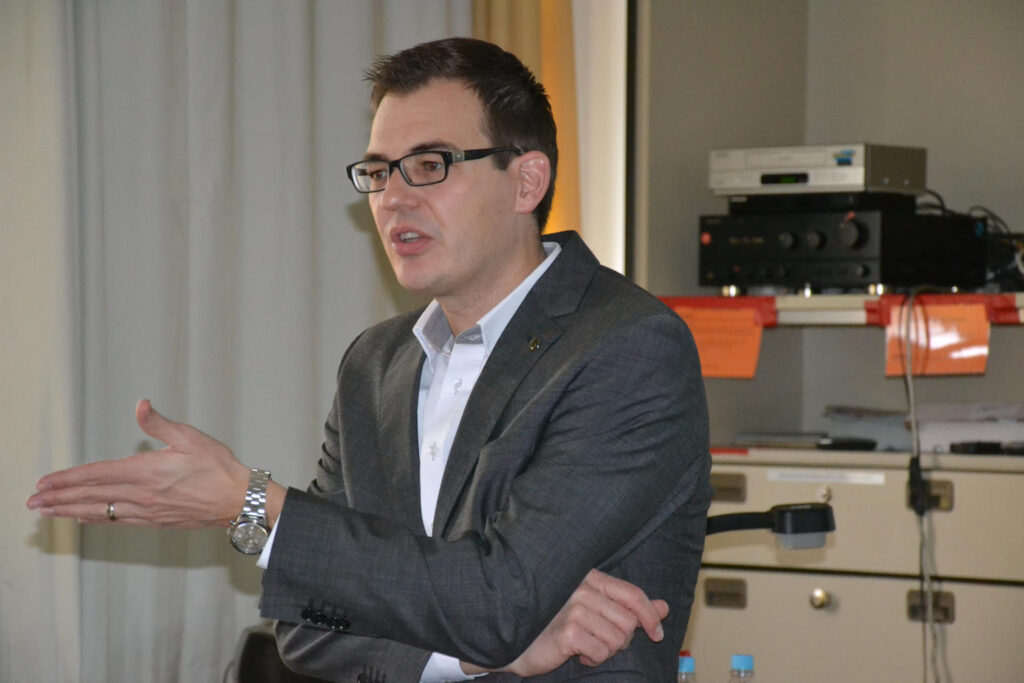 Mann im Anzug hält eine Präsentation im Büro
