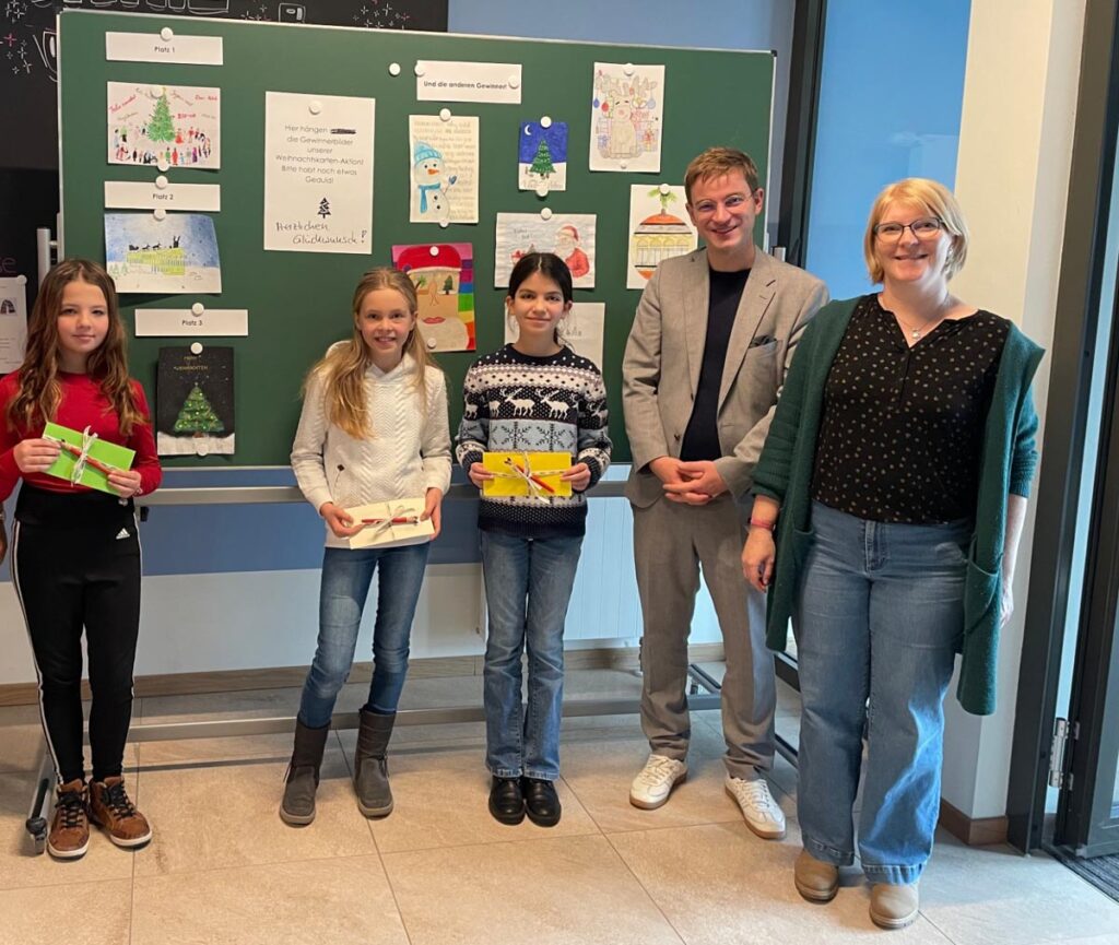 Gruppe von Menschen vor einer Tafel stehend