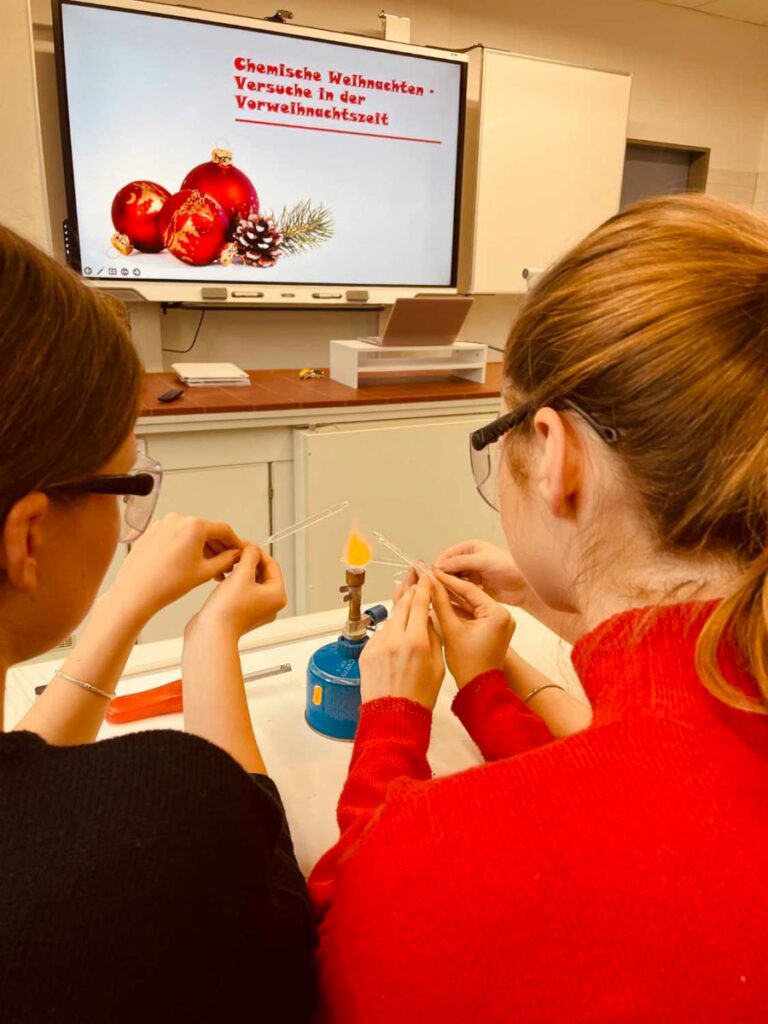 Schüler führen chemische Experimente zu Weihnachten durch.
